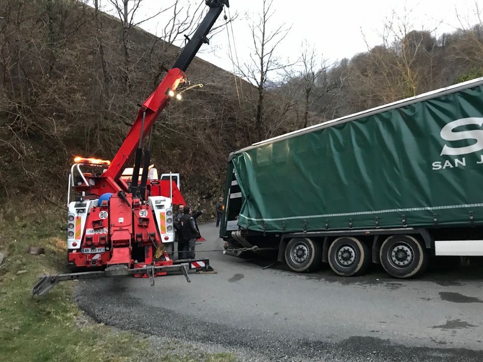 Grue de dépannage rouge Sallaberry remorquant un poids lourd au Pays Basque